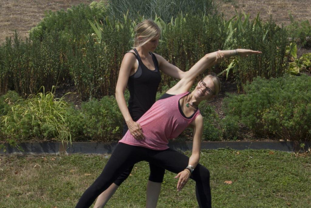 Personal Yoga Frankfurt - Yoga Personal Trainerin richtet eine Teilnehmerin im seitlichen Winkel aus Teaser
